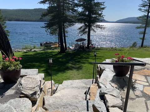 Stone staircase to the lawn. Upper level patio with flagstone.