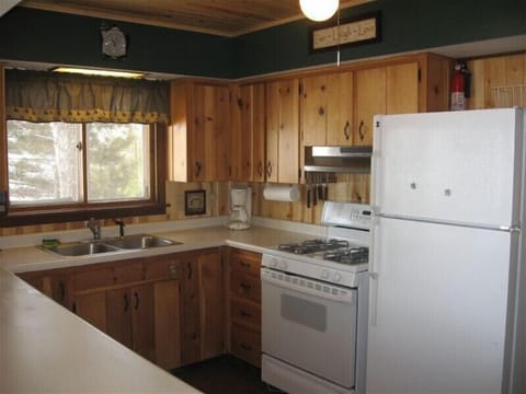 Classic Knotty Pine Kitchen with new appliances, including dishwasher.