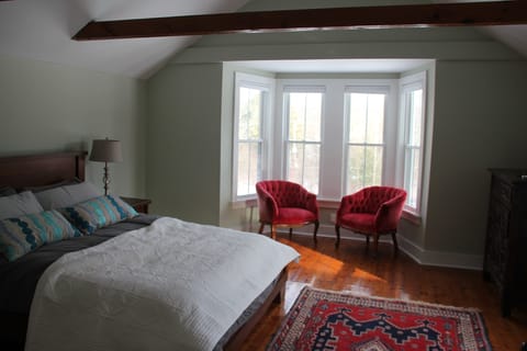 Upstairs bedroom flooded with sun, queen bed.