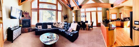 Open floorplan living room with access to kitchen, dining room, bathroom, patio