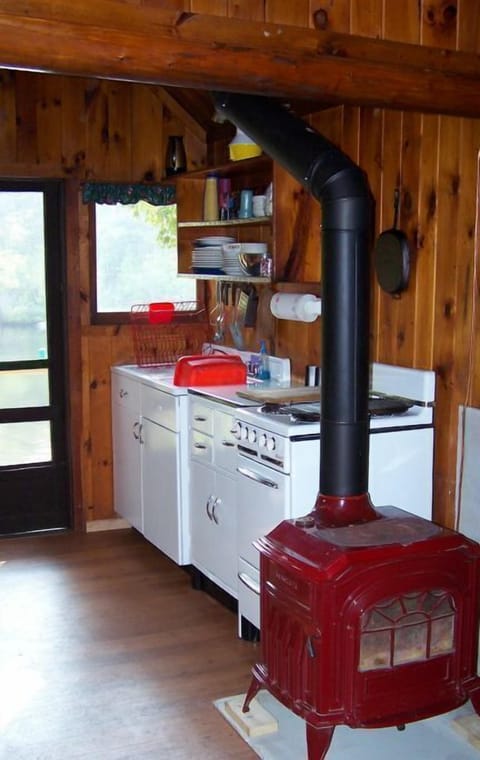 Retro kitchen with original knotty pine, gas cooking stove + wood stove for heat