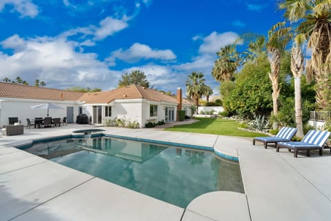 Rear of home with pool & spa and large yard.