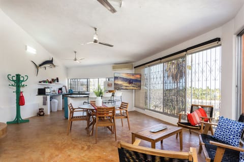 Living room with floor to ceiling windows that offer views to palm trees & ocean