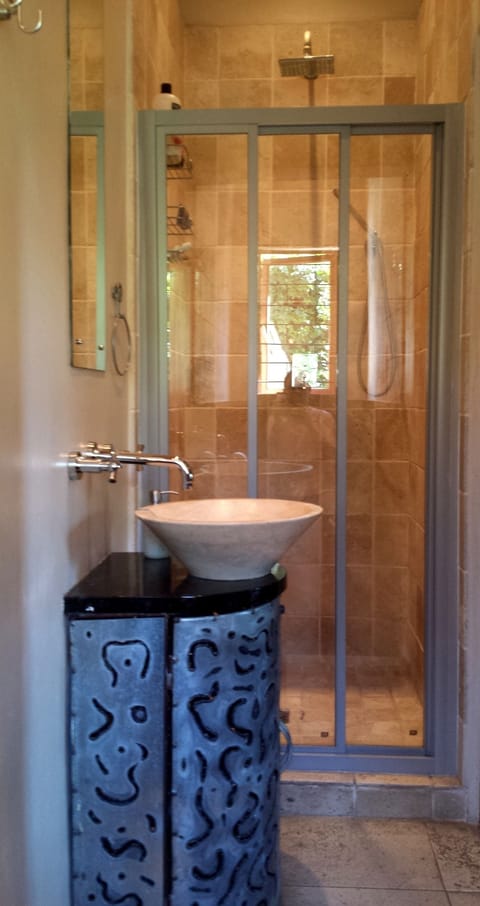 Modern en-suite bathroom with shower, basin and toilet.