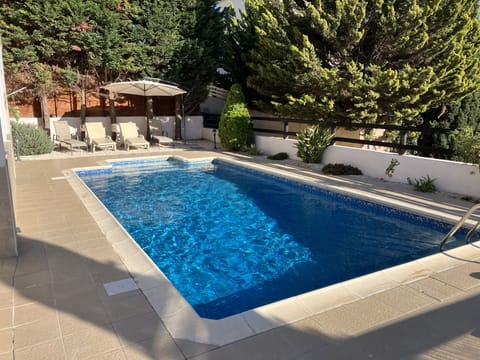 Beautiful pool in South facing garden with  six sun beds and sun umbrellas