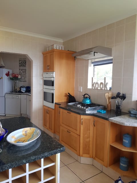 The fully equipped kitchen / gas stove electric oven / island with a wine rack