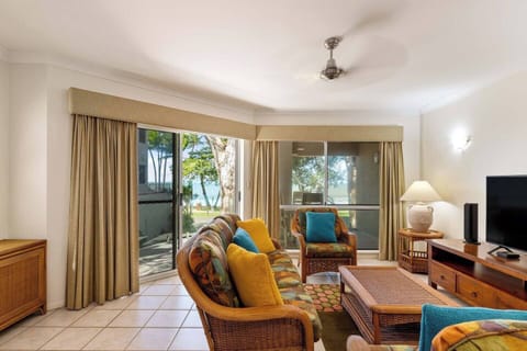 Enjoy the vibrant hues of the living area while staying connected to the outdoors with easy access to the beach just steps away.