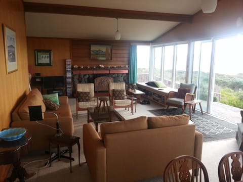 Living room looking towards fireplace. Front deck and beach on the right