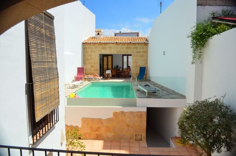 View from the kitchen terrace - pool and outdoor dining area with pizza oven
