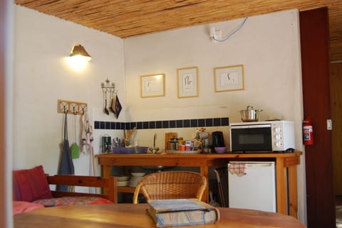 A kitchenette with a fridge, oven & 2 hot plates, kettle, knives, forks etc