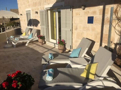 The colourful garden terrace has four adjustable sunbeds with comfy cushions.