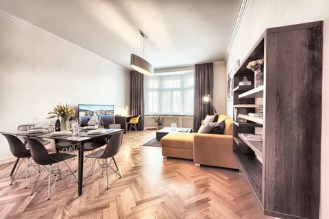 Spacious living room with comfortable sofa, modern flat-screen TV and dining sea