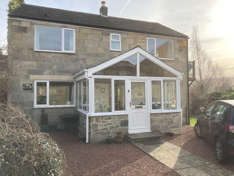 Front of house with parked car and other parking space on other side of entrance