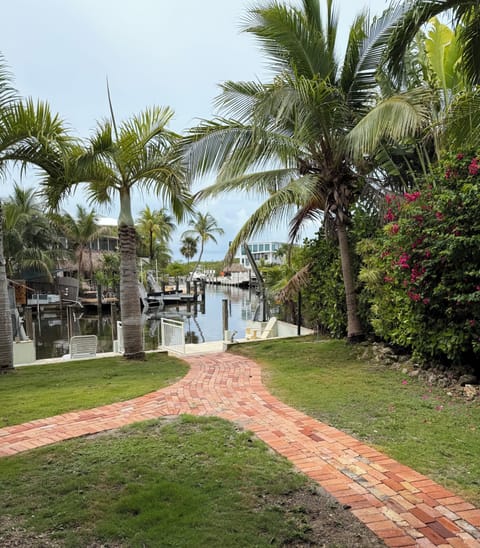 Lush canal front gated estate with water views and easy ocean access.
