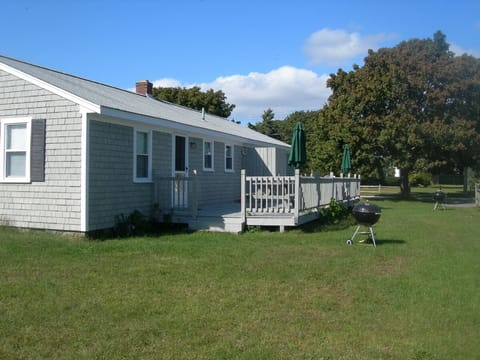 Large yard and deck on back of house with outside shower
