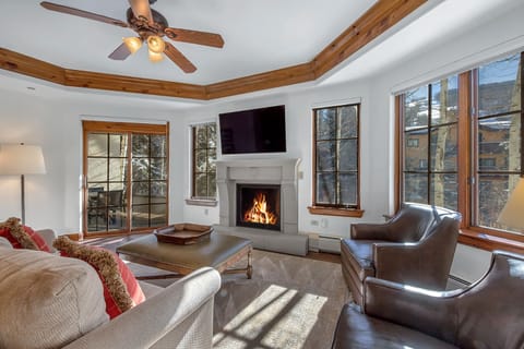 Main living area with outdoor balcony overlooking Gore Creek and the mountains