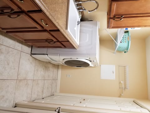 laundry room front loading washer and dryer with storage drawers. large closet