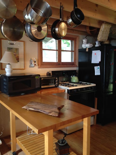 Stove, microwave, refrigerator, chopping block peninsula, plenty of cook ware. 