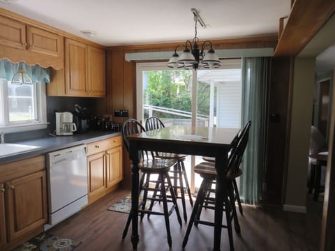 Sliding glass door from kitchen to rear deck on the driveway side of the house.