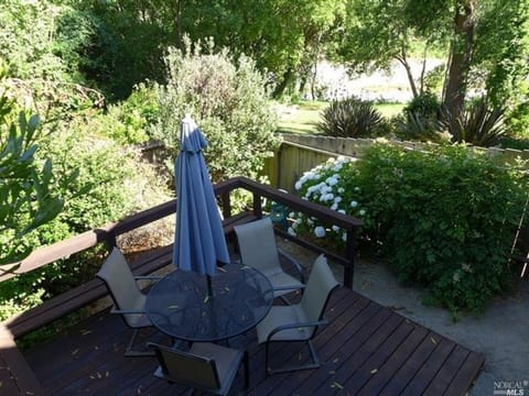 Fenced Back Yard with deck of Cottage #4, looking out to the river