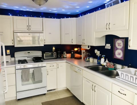 Kitchen, stove, two coffee makers, & coffee supplies.