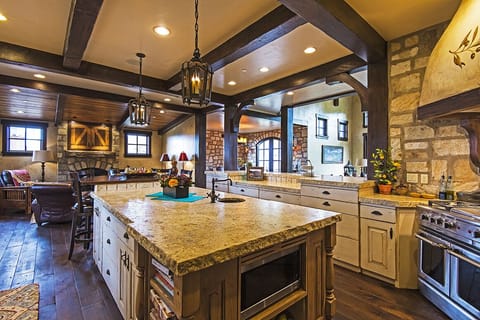 Kitchen w hearth and dining rooms in the background