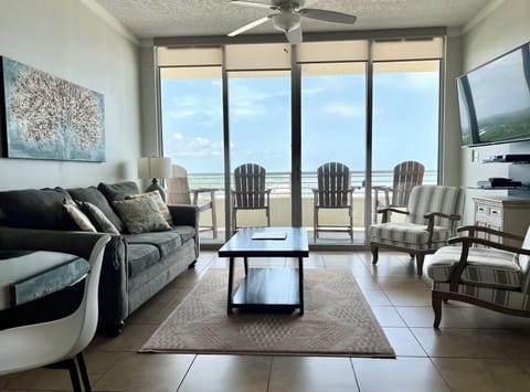 Living area with sofa, two accent chairs, coffee table and a smart TV