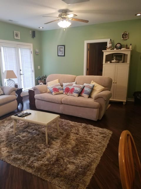 Living room with view of door to lake side and entrance to bathroom.