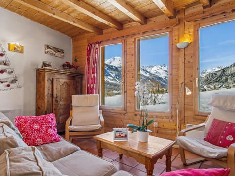 Cozy living room with panoramic view of the snowy mountain.