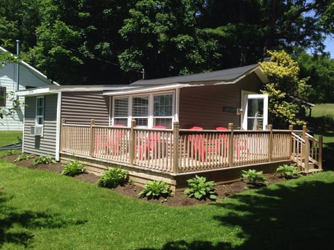 Lake house with wrap-around front deck and adirondack chairs for lounging.