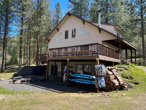 Waterfront side of house with provided beach chairs, paddle board and fire pit