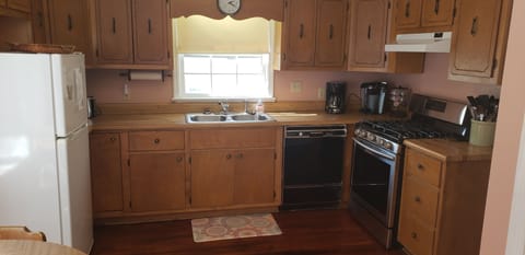 Kitchen with refrigerator, microwave, toaster, dishwasher, and gas oven.