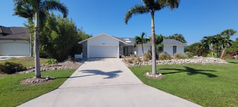 Front of house and garage door with the main entrance to the right.