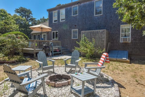 fire pit with 4 Adirondack chairs at rear of home