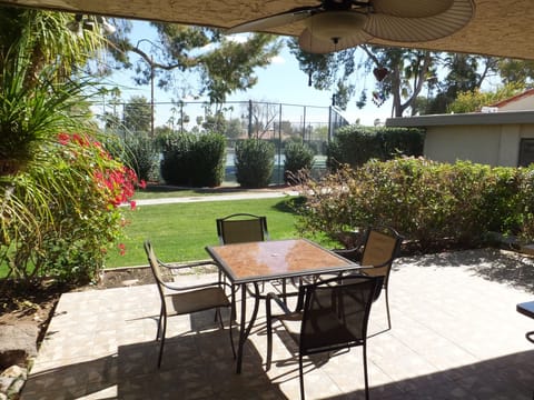 Back patio off of the living room with view of the tennis court