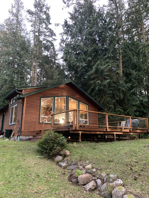 Cabin with front deck and forest from the driveway
