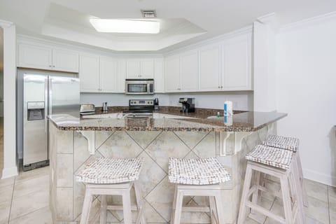 Kitchen featuring stainless appliances, granite countertops, and cozy bar seating for a casual dining experience