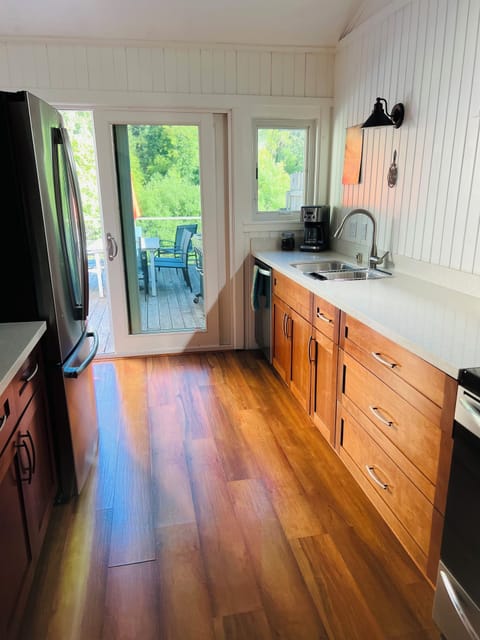 View of fully-stocked kitchen adjoining the deck with propane BBQ