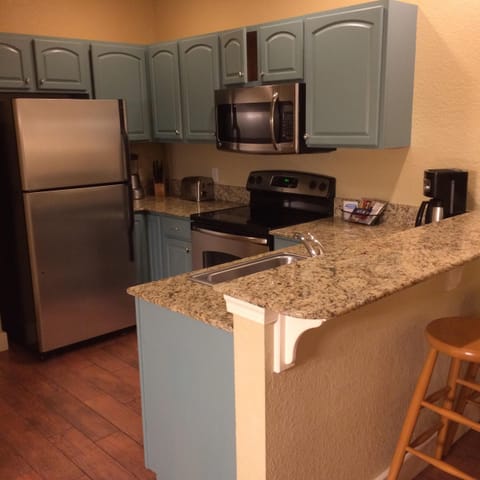kitchen with dishwasher, cookware, and with 3 barstools at peninsula counter