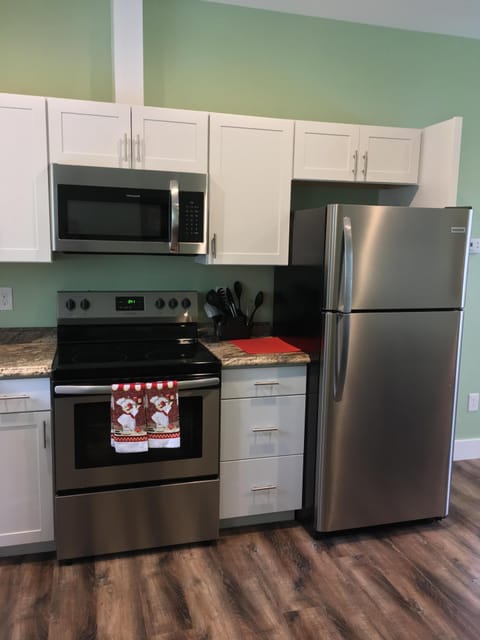 Full sized refrigerator with cabinets stocked with cooking supplies, dishes, etc