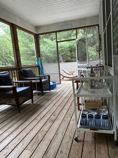 Deck with seating and bar cart with plastic wine glasses, bucket, etc.