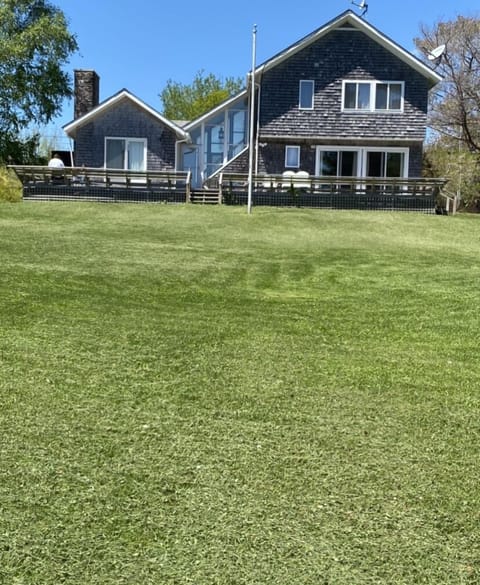 Looking up from ocean over large lawn to house
