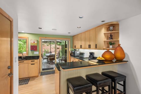 A dining table for 8 indoors, another outdoors and a breakfast bar for 3 create many spots to dine or have a hot cup of coffee.