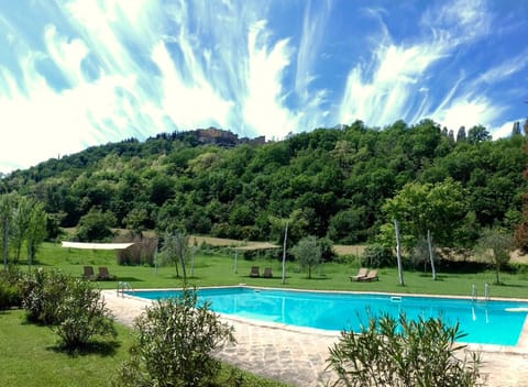 The large Pool of the Agriturismo with views of medieval Montone
