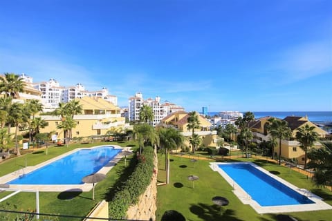 View of the community swimming pools and gardens from the apartment balcony