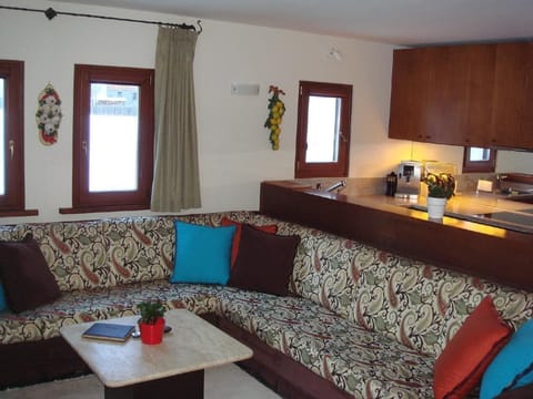 View into the kitchen with sofa in front. The kitchen is equipped with a granite top.
