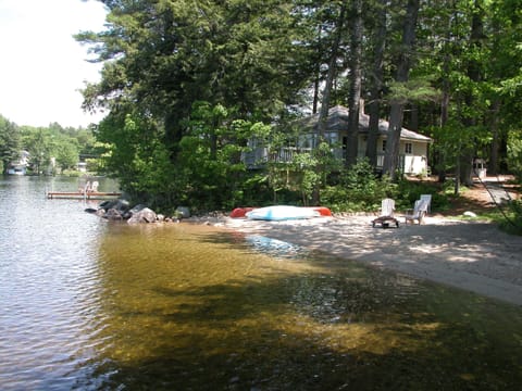 view of cottage showing the all sand beach, separate dock and lakefront deck