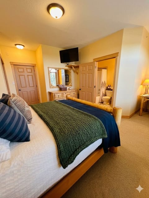 Master Bedroom with custom log Queen Bed, TV, Cable and s Desk (just in case you need to do some work?).