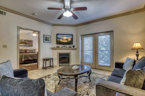 Living Room, TV, Door, Ceiling Fan, Tile Floor, Couches, Table, Lamp, Fireplace.
