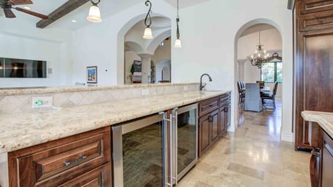 Spacious kitchen with granite counters, wine fridge, and open design.